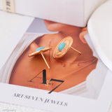 Gold earrings with turquoise stones on a magazine page