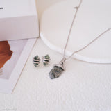 Jewelry set with necklace and earrings on a textured surface