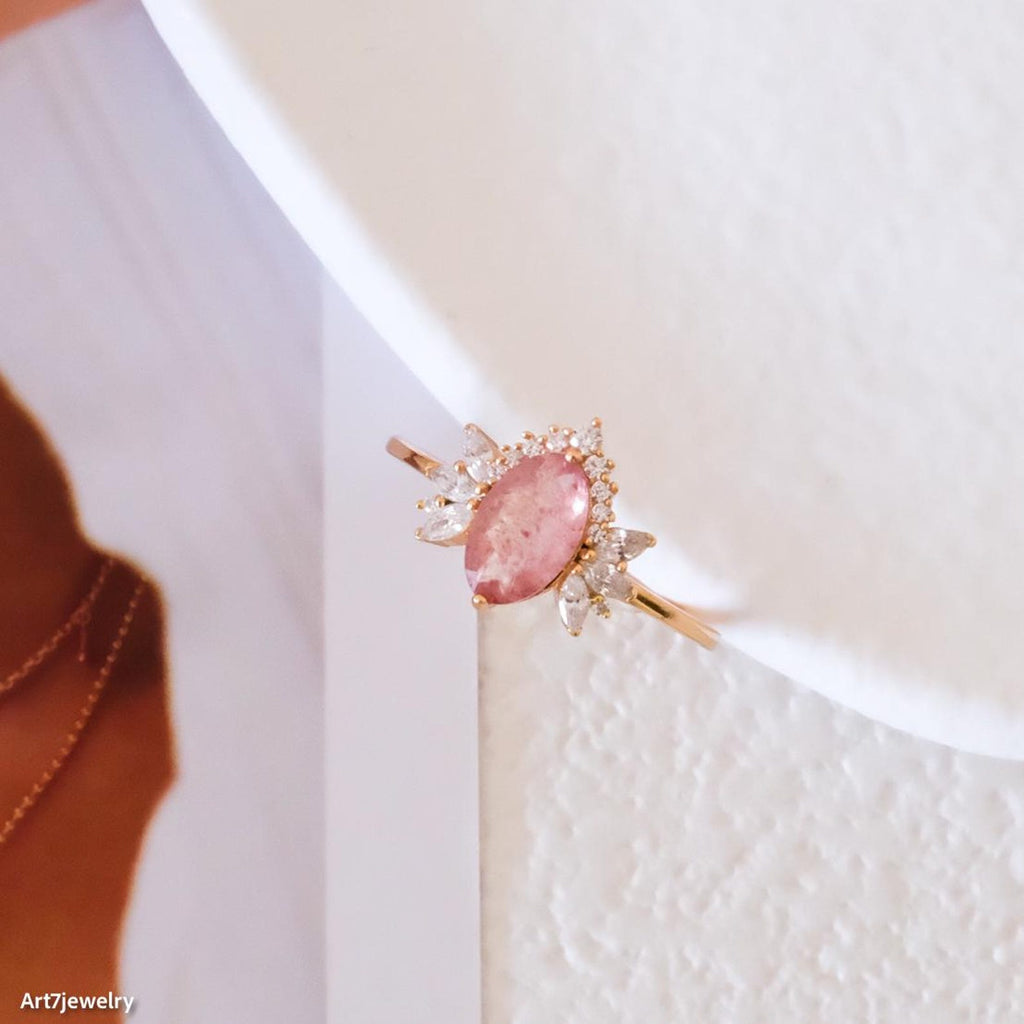 Jewelry with a pink stone and gold accents on a white background