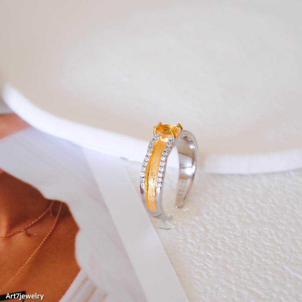 Two-tone ring with a yellow gemstone on a white surface, brand 'Art7jewelry' visible.