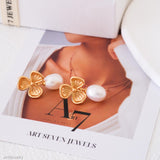 Gold butterfly earrings with pearls on a magazine page with 'Art Seven Jewels' branding.