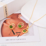 Gold jewelry set with green stones on a magazine