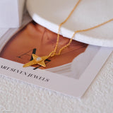 Gold necklace with a star pendant on a magazine page with 'Art Seven Jewels' branding.