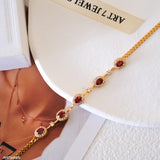 Natural garnet tennis bracelet featuring genuine deep red garnet gemstones surrounded by sparkling halo accents, set in a delicate gold bracelet design, elegant January birthstone jewelry and timeless gemstone gift for women.