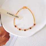 Natural garnet tennis bracelet featuring genuine deep red garnet gemstones surrounded by sparkling halo accents, set in a delicate gold bracelet design, elegant January birthstone jewelry and timeless gemstone gift for women.