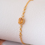 Natural citrine bracelet featuring a genuine golden yellow citrine gemstone surrounded by a sparkling halo, set on a delicate gold chain with bezel accents, elegant November birthstone jewelry for women.