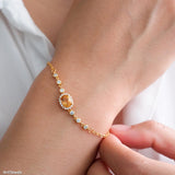 Natural citrine bracelet featuring a genuine golden yellow citrine gemstone surrounded by a sparkling halo, set on a delicate gold chain with bezel accents, elegant November birthstone jewelry for women.