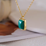 Natural malachite necklace featuring a genuine rectangular green malachite gemstone with distinctive banding in a polished gold bezel pendant on a delicate gold chain, elegant minimalist gemstone jewelry for women.