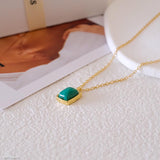 Natural malachite necklace featuring a genuine rectangular green malachite gemstone with distinctive banding in a polished gold bezel pendant on a delicate gold chain, elegant minimalist gemstone jewelry for women.