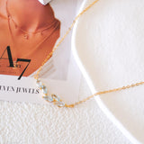 Natural aquamarine necklace featuring five genuine marquise-cut aquamarine gemstones in a delicate curved gold bar design on a fine gold chain, elegant March birthstone jewelry for women.