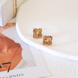 Clover shell stud earrings with iridescent natural shell inlays and gold-tone openwork radiating line details.