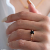 Square black onyx ring in a detailed gold-tone setting with sparkling clear stone accents along the band.