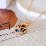 Model wearing blue teardrop crown necklace with gold chain