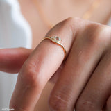Pear-cut light blue aquamarine wave ring in a gold-tone setting with a delicate clear stone accent.