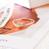 Pear-cut light blue aquamarine wave ring in a gold-tone setting with a delicate clear stone accent.