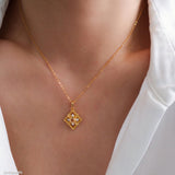 Gold-tone citrine clover pendant necklace with a faceted yellow center stone and sparkling clear stone accents.