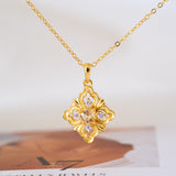 Gold-tone citrine clover pendant necklace with a faceted yellow center stone and sparkling clear stone accents.