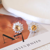 Citrine sunflower stud earrings with golden-yellow center stones and clear baguette-cut halo accents.