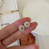 Citrine sunflower stud earrings with golden-yellow center stones and clear baguette-cut halo accents.