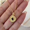 Gold sapphire pendant necklace with natural blue sapphire center stone, surrounded by small sparkling accents on a textured round gold disc, delicate minimalist chain jewelry for women